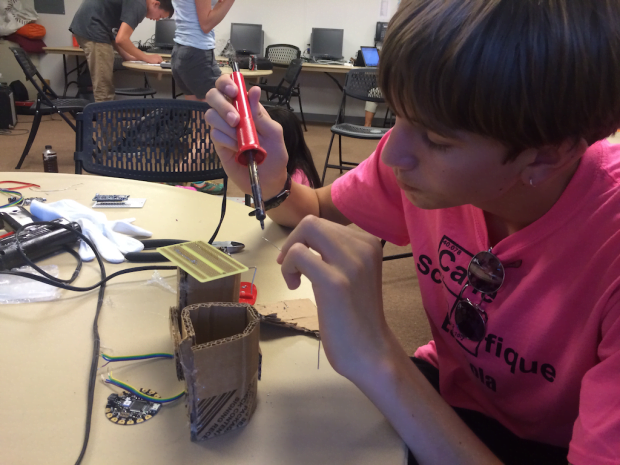 Emmett solders a prototype breadboard.