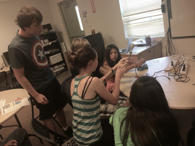 Hailey leads the group who learns how to solder wires to a small prototype breadboard.